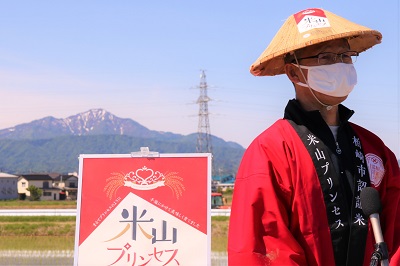 米山プリンセスのロゴが入った笠をかぶった櫻井市長と、米山プリンセスのポスター