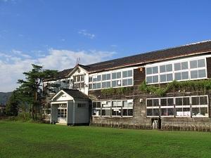 青空を背景にした木造校舎の写真
