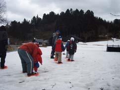 雪の上を歩く子どもたちの写真
