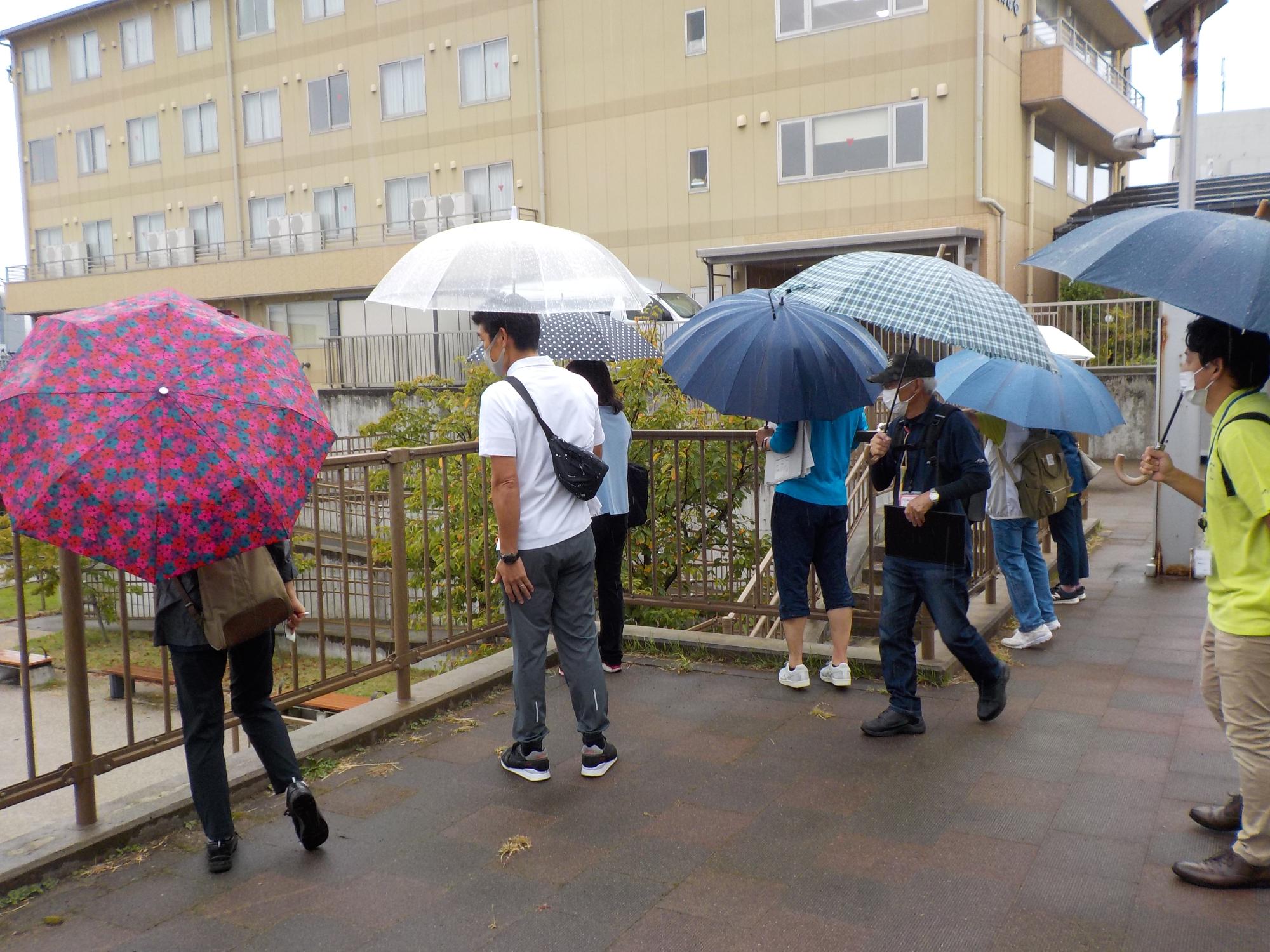 写真：雨の降る中、傘を差してまちなかウオークイベントに参加した皆さん