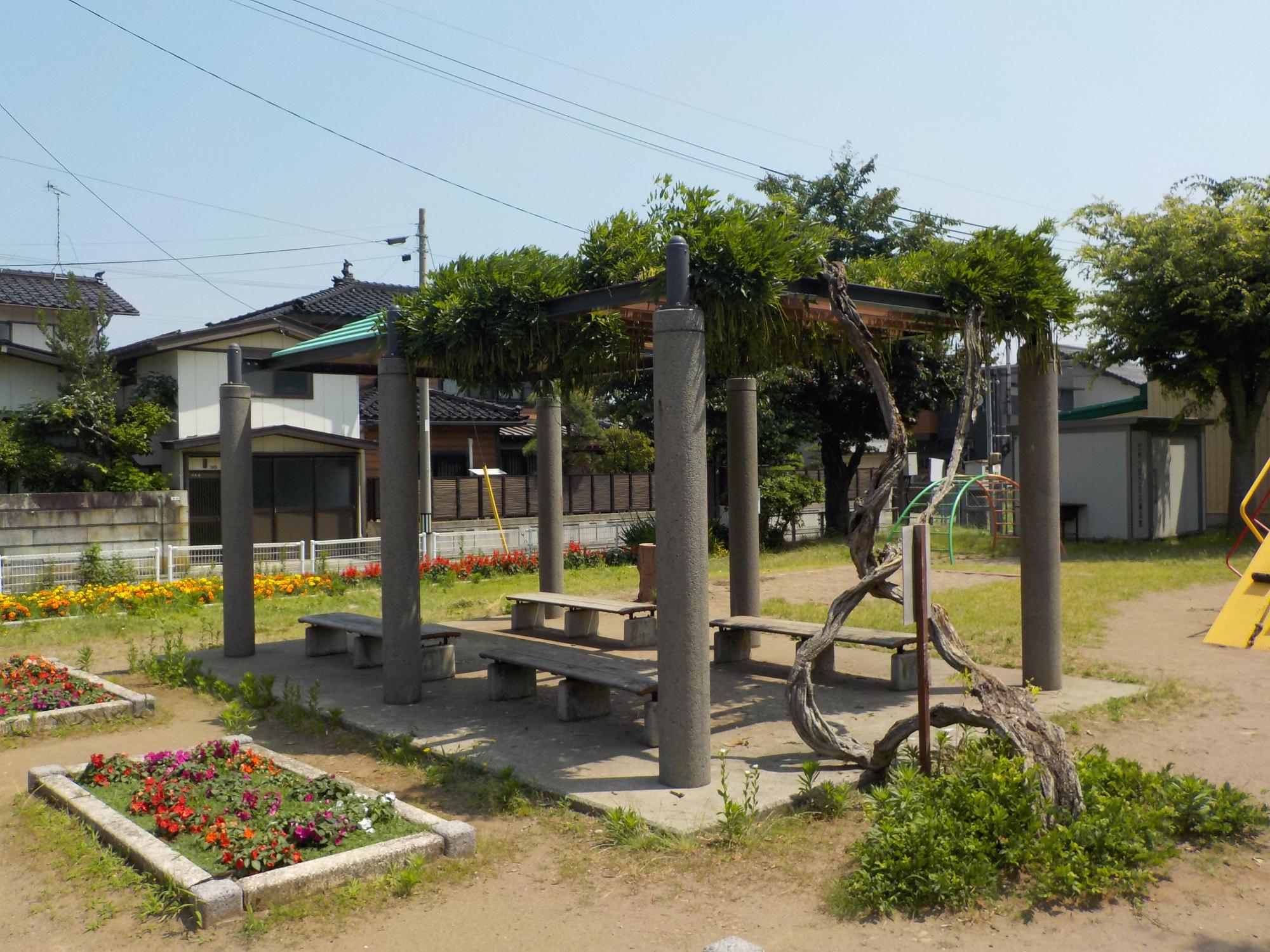 写真：パーゴラとあずまやは隣り合って設置され、その下にベンチが2つずつあります