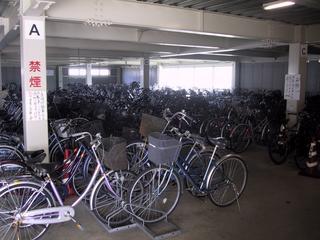 立体駐輪場の一階に自転車がぎっしりと駐車されている写真
