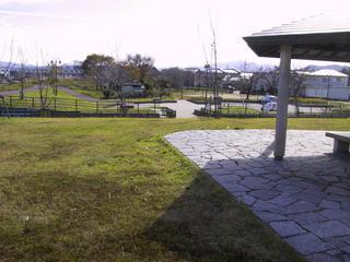 公園の芝生と屋根付きの休憩所が写っている写真