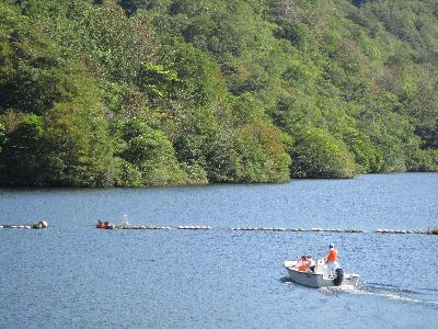 写真：広いダム湖を進む1台のボート