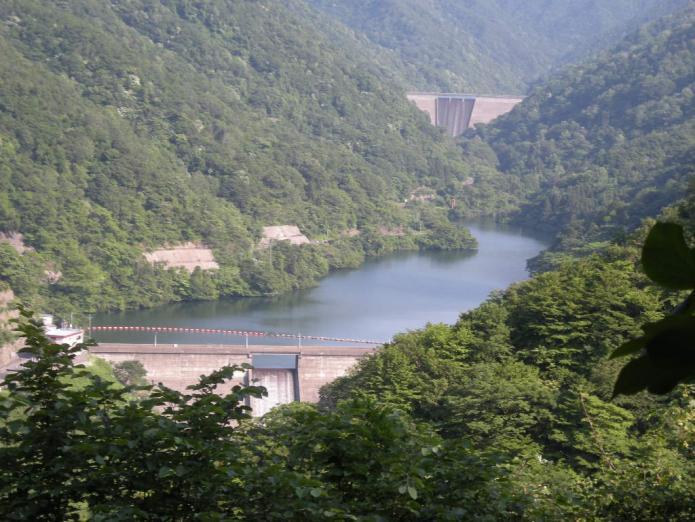 緑の山囲まれた谷根ダムの奥に赤岩ダムが写っている写真