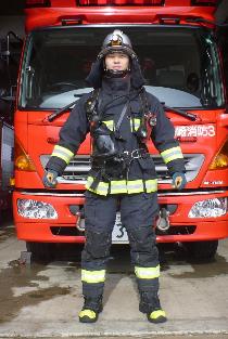 消防車の前に防火服と空気呼吸器を着装した消防隊員が立っている写真