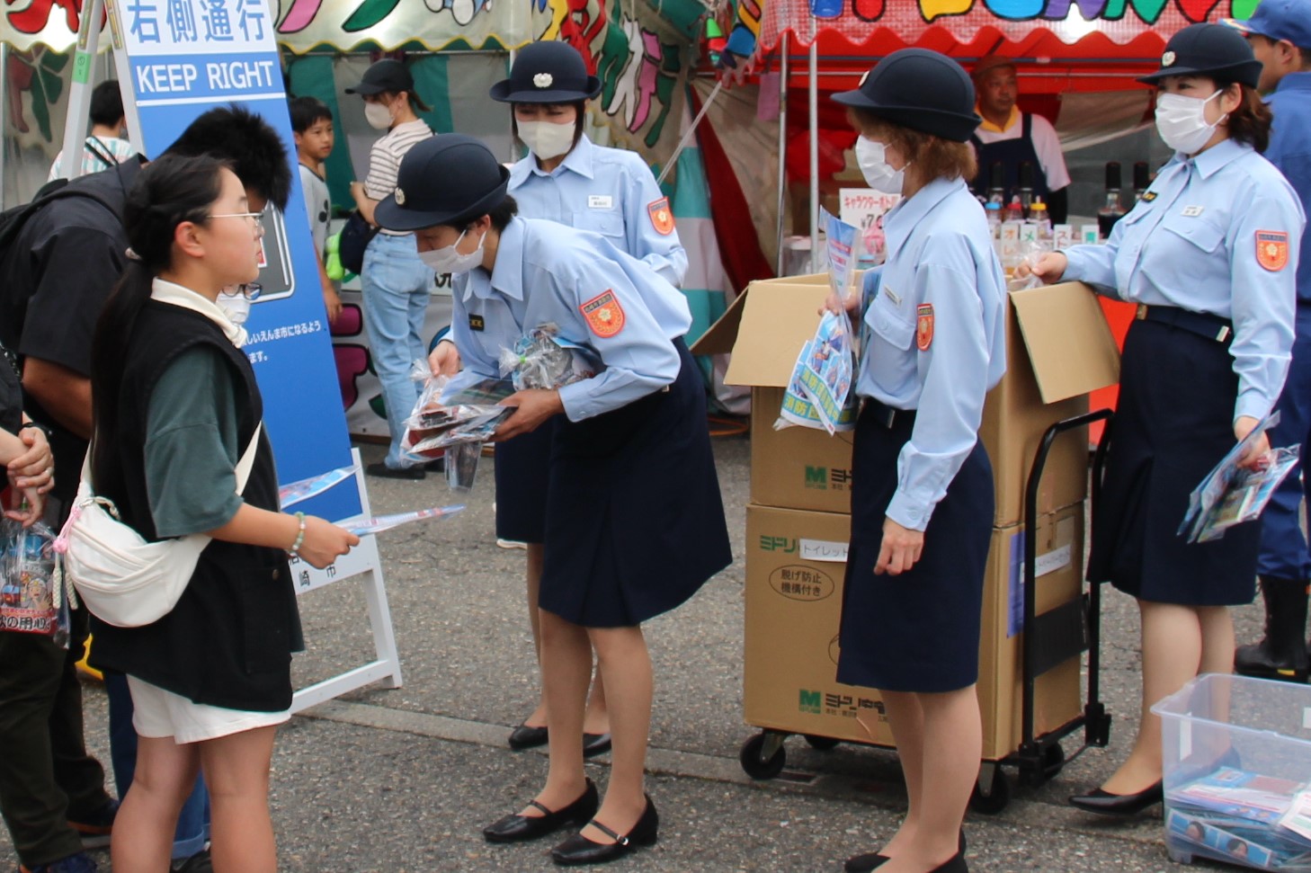 写真：来場者へパンプレットを配布する女性消防隊員