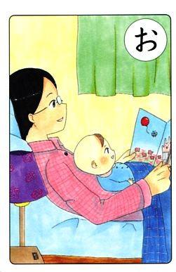夜寝る前に布団の中でお父さんが赤ちゃんに絵本を読んでいる絵が描かれている「お」のカルタの写真