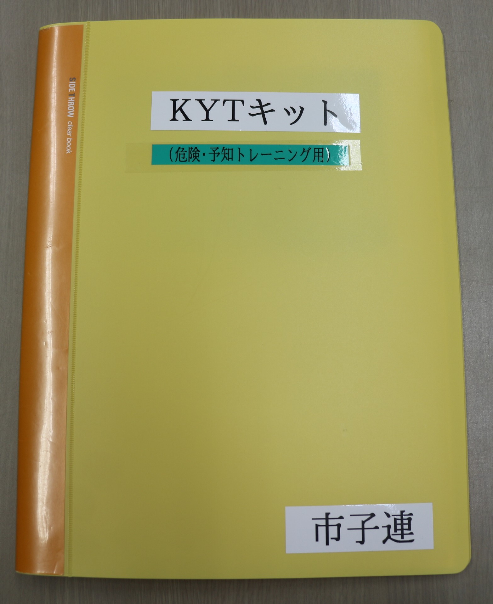 黄色のクリアブックに、黒い文字で「KYTキット危険・予知トレーニング用」という文字が書かれたKYTキットの写真