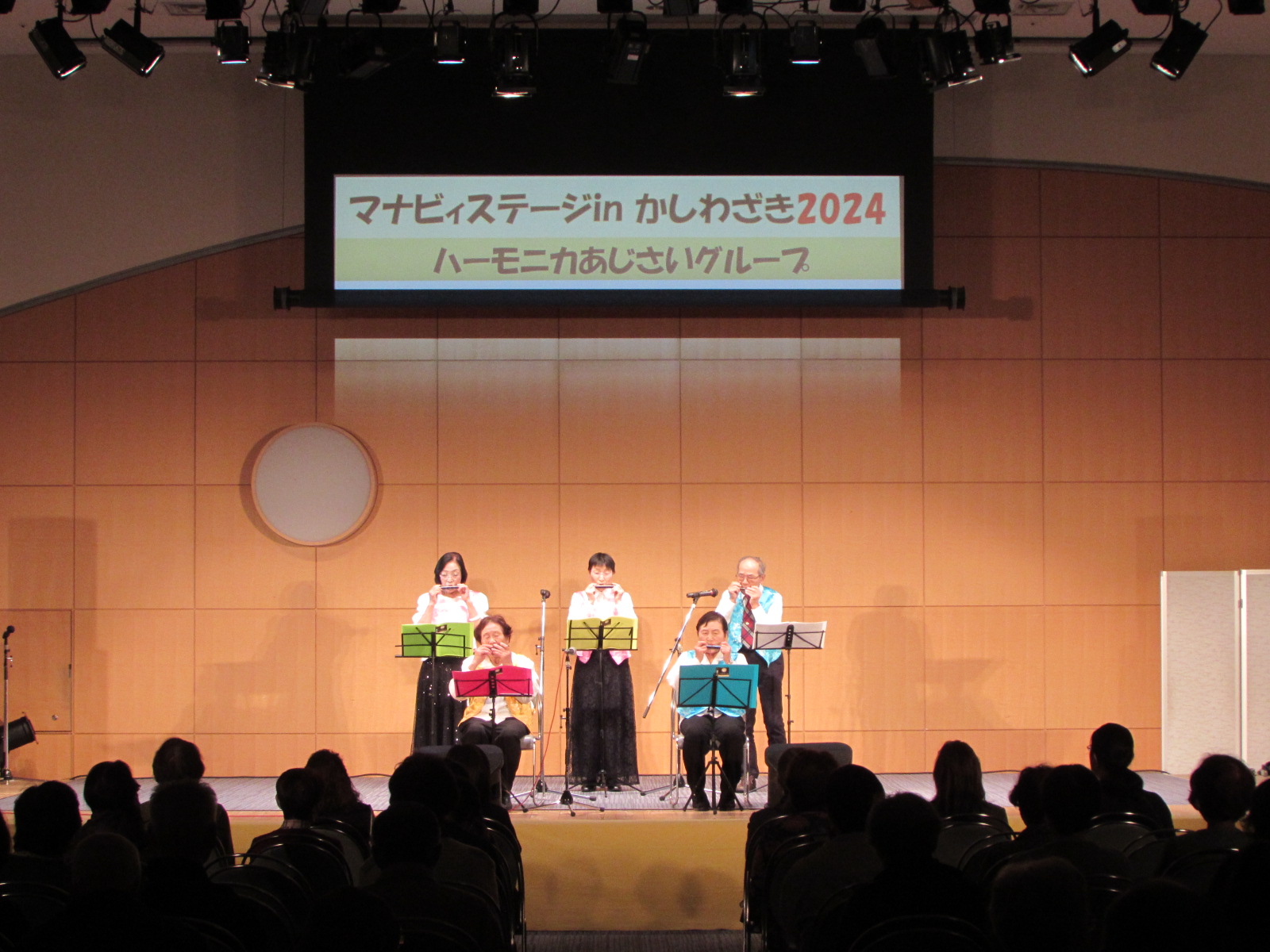 写真：出演者がハーモニカを演奏する様子