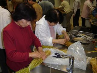 2人の女性が講座で納豆作りを習っている写真