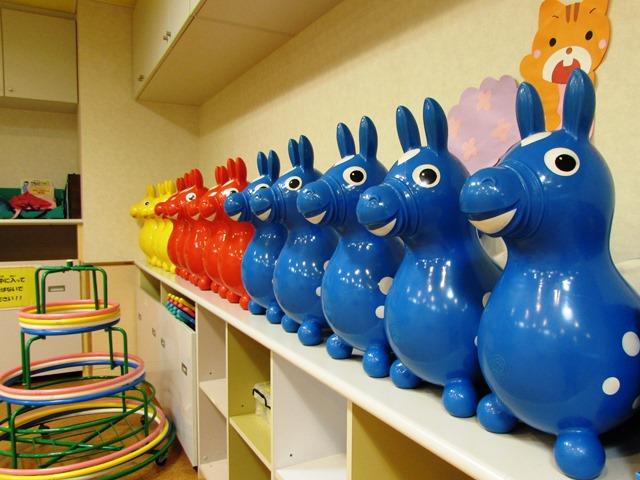 赤、黄色、青の体を動かして遊ぶおもちゃが壁際に並んでいるの写真