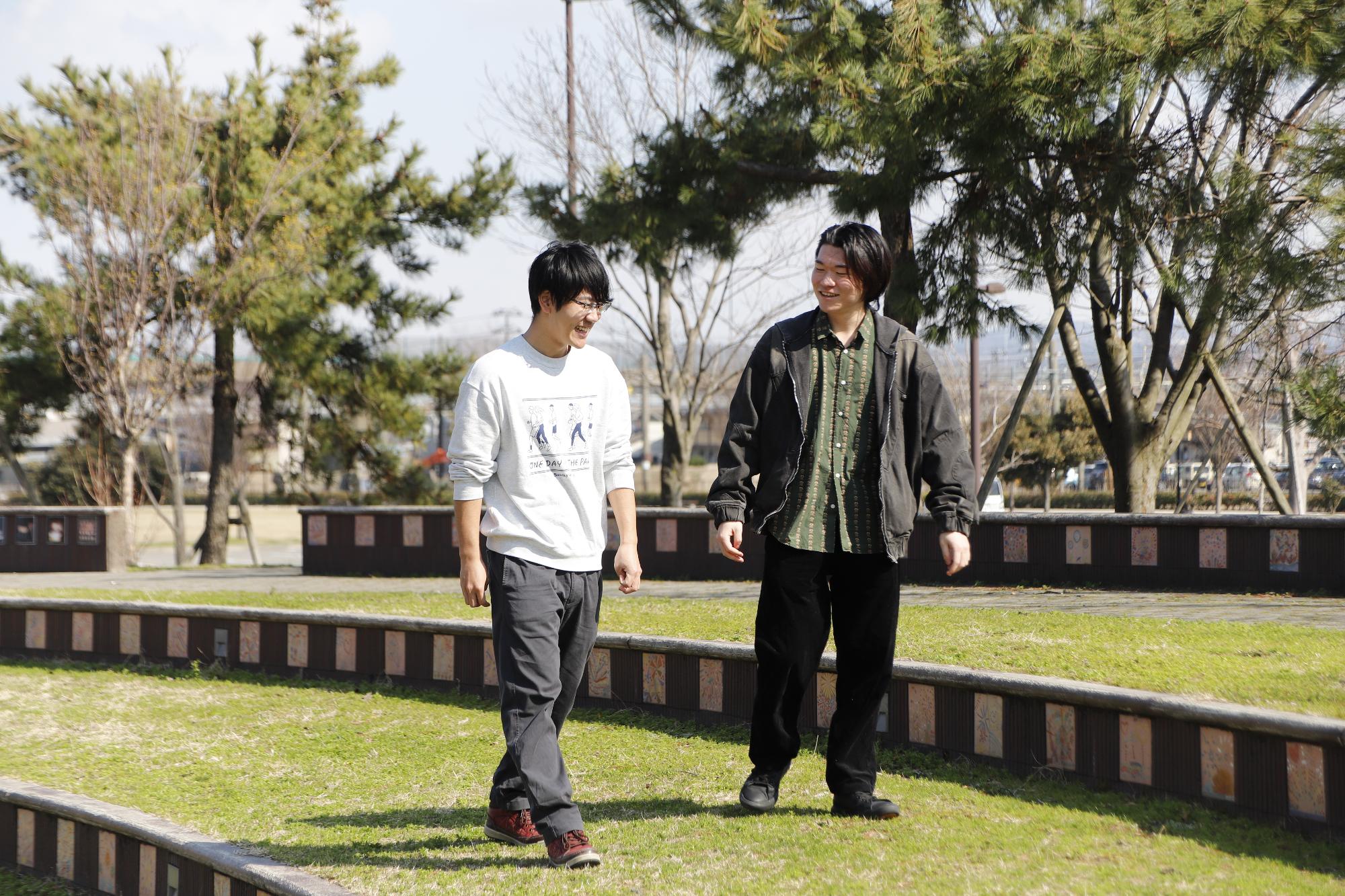 写真：木々に囲まれた劇場広場の客席を歩く渡邊さんと増田さん。客席は階段状になっていて、どこに座ってもステージが見えるように設計されています