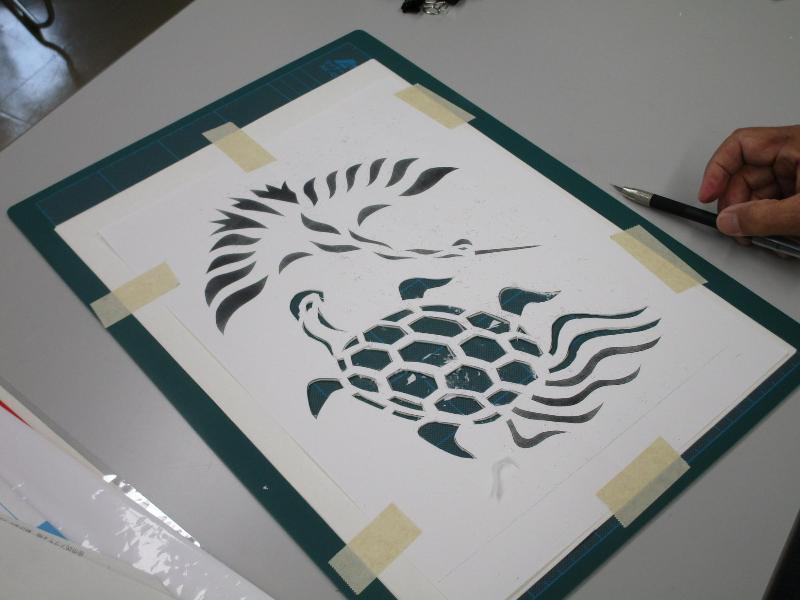 写真：白い紙に鶴と亀の模様を切り抜き、深緑色の色紙を重ねた八丁紙