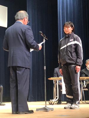 写真：山田果林さんの前で表彰状を読み上げる坂井会長