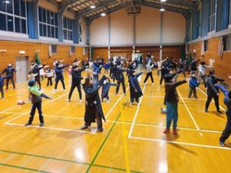 写真：参加者がラジオ体操のからだをねじる運動をする様子