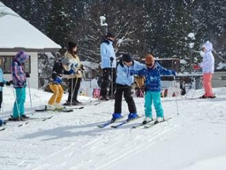 写真：参加者が傾斜を利用して滑る練習をしています。参加者と一緒に指導者も滑りながら指導しています