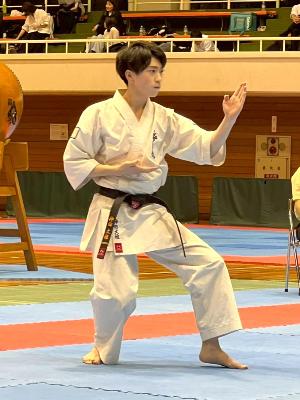 写真：技を披露する神田大雅選手。腰を少し落とした状態で左足を前に出し、左手を胸の前に立て、右手を胸の下に添えています