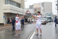 トーチの先端を合わせてトーチキスをする2人のランナー