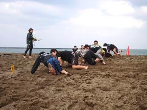 写真：砂浜の上で実技の研修を受けています