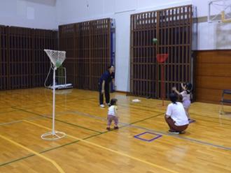 写真：スタッフが投げたボールを少し離れた所に立った参加者が取ろうと腕を伸ばしている様子