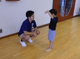 写真：子どもが手首を下げた両手を顔の前に出し、おばけになりきって大人にジェスチャーで伝える様子