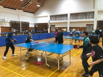 写真：写真奥の女性が手を伸ばし球を相手に返す様子。相手はラケットをかまえています