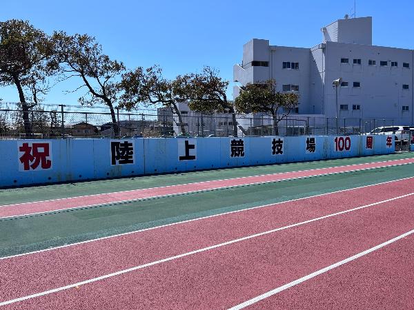 写真：陸上競技場の柏崎小学校側のフェンスに祝陸上競技場100周年のパネルを掲出した写真です