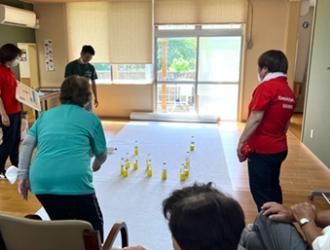 写真：参加者がペットボトルモルックをしています。その様子を赤いポロシャツを来たスポーツ推進員が見守っています