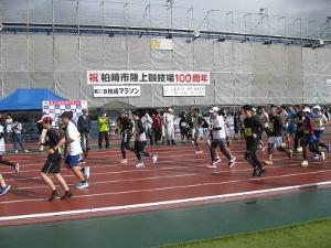 写真：陸上競技場のメインスタンド前を走っていく参加者