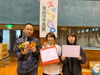 写真：Cブロックで優勝したジンジャーズチーム。右側の方が賞状、左側の方が景品をこちらに向けています