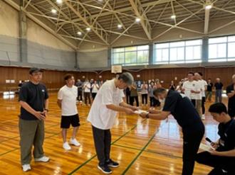 写真：入賞したチームがスポーツ推進委員から賞状を受け取る様子