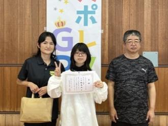 写真：Aブロックで優勝したチーム柏木Aチーム。写真中央の女性が賞状を持ち、ピースをしています