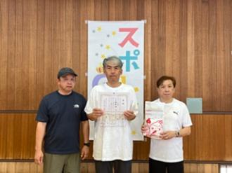 写真：Bブロックで準優勝したチーム柏木B。男性3人のチームで中央の参加者が賞状を右側の参加者が賞品をこちらに向けています