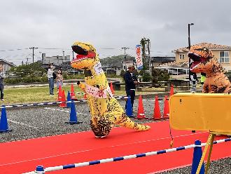 写真：ティラノサウルスレースの様子です。2体のティラノサウルスがゴール前に敷かれた赤いじゅうたんの上を走っています