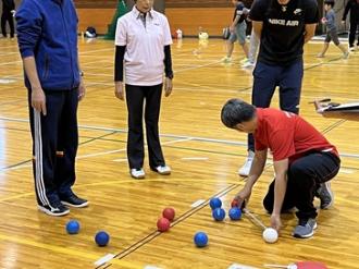 写真：スポーツ推進委員がボッチャの得点集計をしています。メジャーを使用しジャックボールからの長さを計測しています