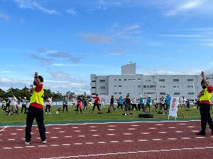 写真：参加者とスポーツ推進委員が柏崎市陸上競技場にてラジオ体操をしている様子です