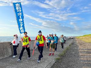 写真：ウオーキングをしている様子でスポーツ推進委員が先頭に立ちその後ろを参加者が歩いている様子です