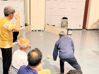 写真：参加者がボウリックをしています。数字の書かれたピンに向かってボールを投げています
