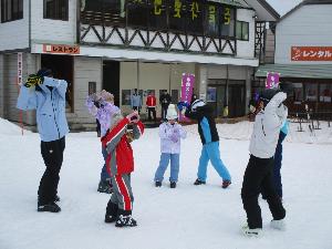 写真：スキースクールの参加者が準備体操をしている様子です