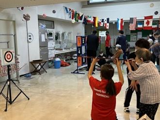 写真：スポーツ推進委員が高齢者にスポーツ吹矢を教えている様子