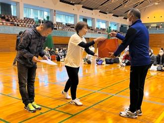 写真：表彰式の様子。参加者の男性が賞状、女性が副賞をそれぞれ受け取っています