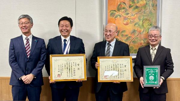 写真：表敬訪問した3人と櫻井市長が、笑顔で並んでいます。大西選手と連盟幹部が、2枚の賞状と総合優勝の盾をそれぞれ持っています。