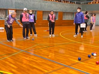 写真：男性が青色のボールをジャックボールに向かって投球する様子。