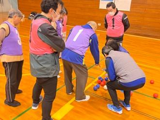 写真：参加者複数人が試合終了後の集計を確認する様子