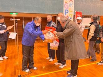 写真：スポーツ推進員箕輪会長から入賞者へよねやまプリンセスが手渡される様子
