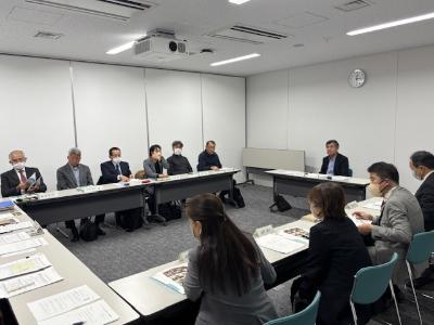 写真：ロの字型に机を並べた会議室で、議題を審議・検討するスポーツ推進審議会の委員の皆さん