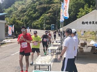 写真：黒滝給水所の様子。机にコップが並べられランナーが取っています。