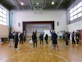 写真：参加者がじゃんけん大会をする様子。ステージ上にパーの看板が出されています