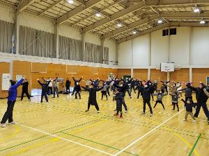 写真：枇杷島コミュニティセンターに集まった参加者がラジオ体操をしている様子で後ろそりをしています